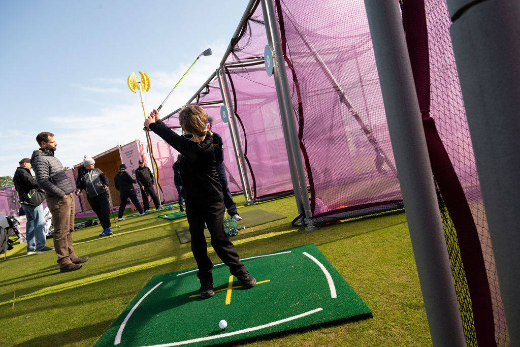 A young golfer takes a swing at the practice range at the AIG Women's Open.